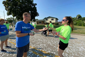 Volunteer handing out water at the Packers 5K, Bellin sponsored event