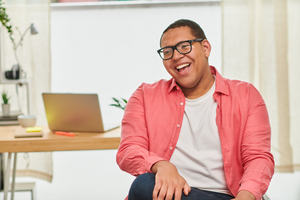 Portrait of happy, confident young man in office laughing